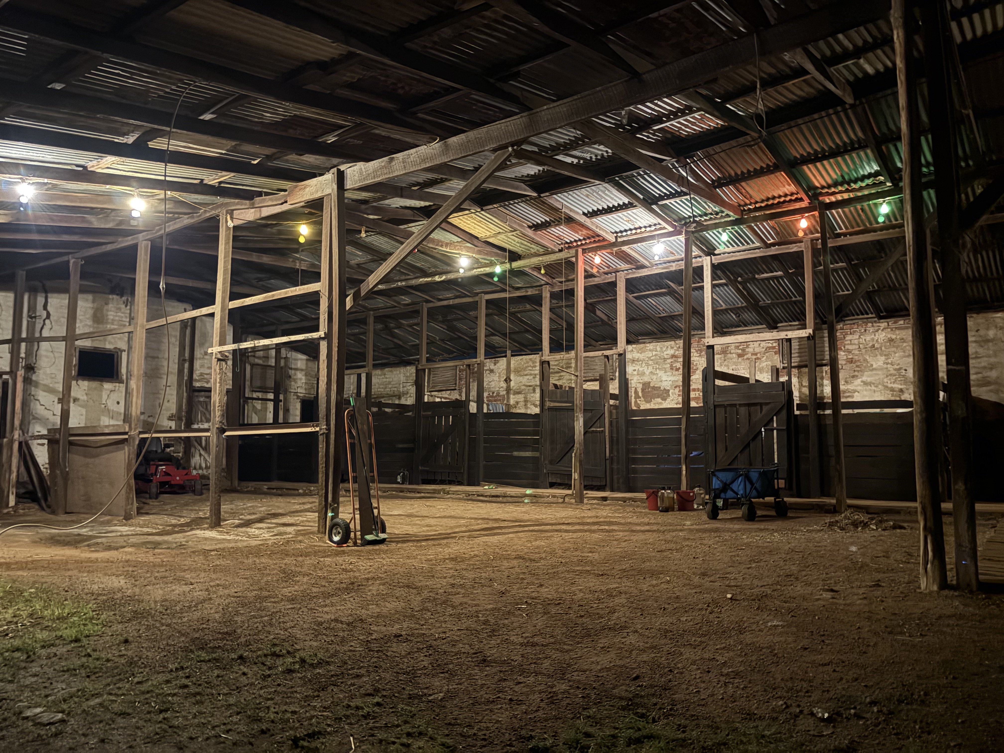 Inside the stables at Guildford Farm lit by string lights after dark